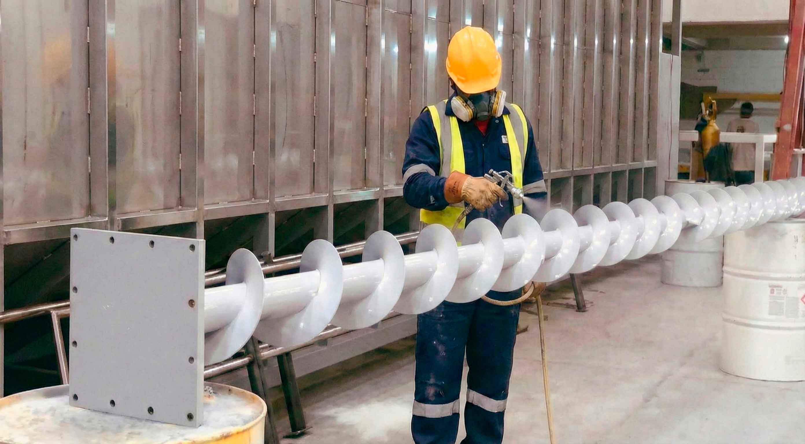 Operario aplicando recubrimiento epóxico al tornillo